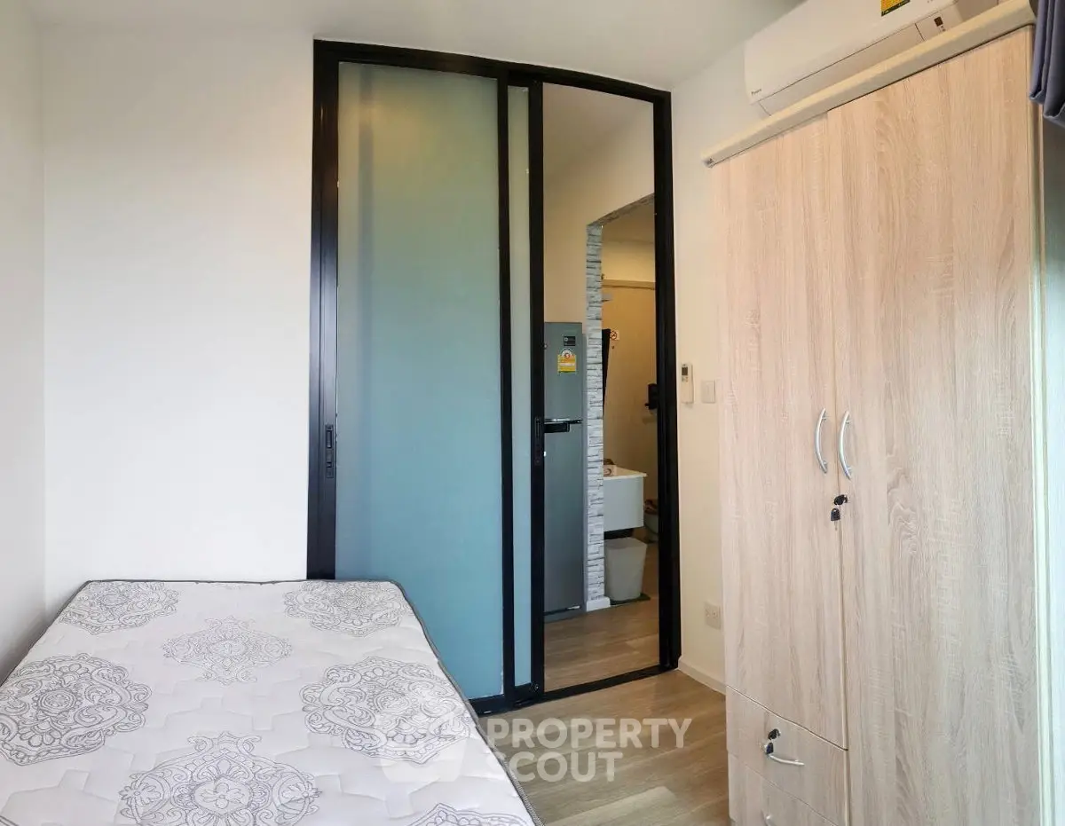 Cozy bedroom with modern sliding door and wooden wardrobe