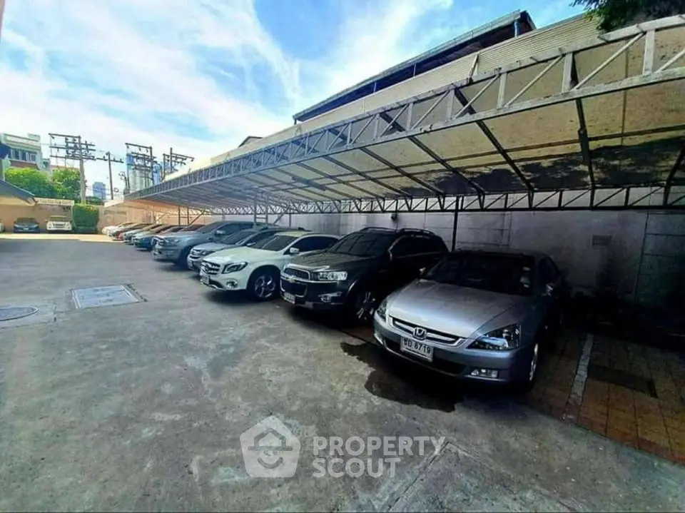 Spacious covered parking area with multiple cars in a secure residential complex.