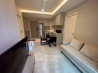 Modern open-layout kitchen and living area with sleek design and cozy ambiance.
