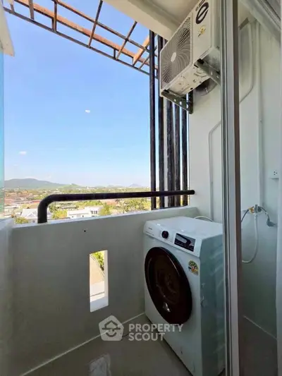 Charming balcony with washing machine and scenic view, perfect for urban living convenience.