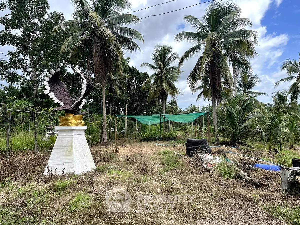 Tropical garden with palm trees and unique eagle statue, ideal for serene outdoor living.