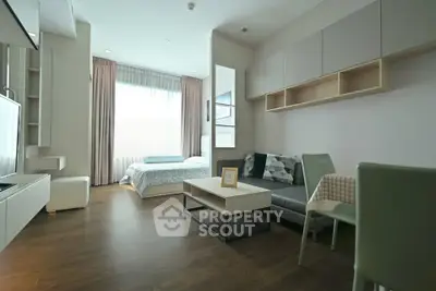 Modern studio apartment with open layout, featuring a cozy living area and a comfortable bed.