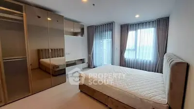Spacious modern bedroom with large windows and elegant furnishings in a luxury apartment.