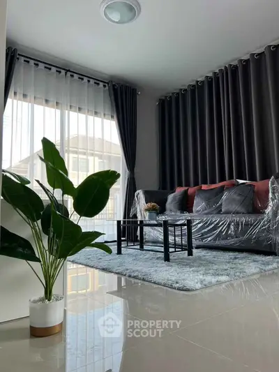 Modern living room with stylish decor, large windows, and elegant curtains.