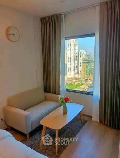 Cozy living room with city view, featuring a beige sofa and wooden coffee table.
