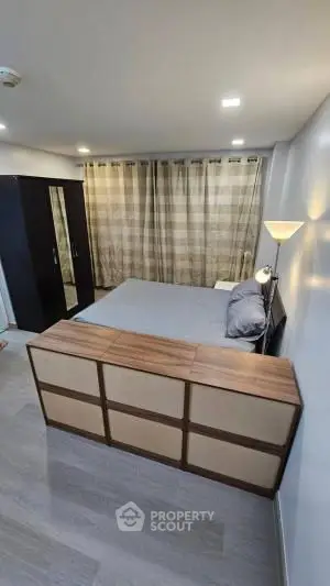 Cozy bedroom with modern furnishings and ample natural light, perfect for relaxation.