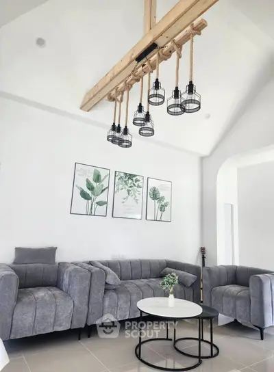 Modern living room with stylish gray sofas and unique hanging light fixture, perfect for contemporary living.