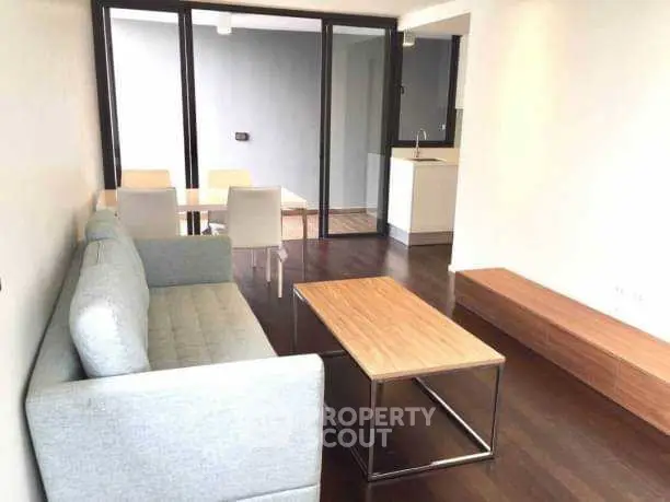 Modern living room with sleek furniture and dining area in open layout.
