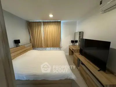 Cozy bedroom with modern furnishings and natural light, perfect for relaxation.