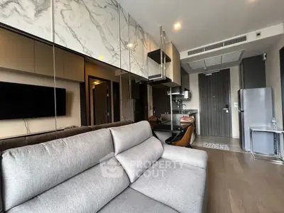 Modern living room with sleek kitchen and stylish decor in open layout apartment.