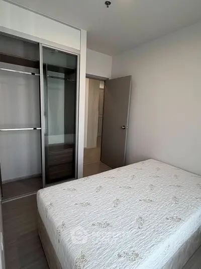 Cozy bedroom with modern sliding wardrobe and comfortable bed in a stylish apartment.
