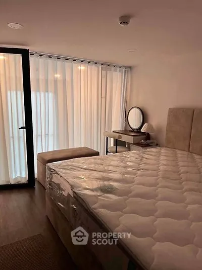 Cozy bedroom with large window and elegant furnishings, perfect for relaxation.