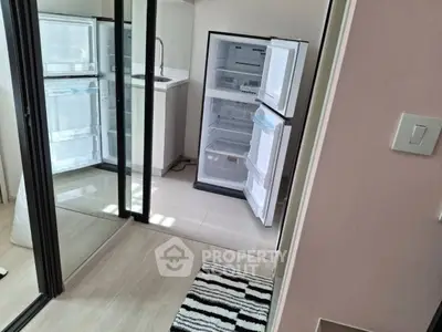 Modern kitchen with open fridge and sleek mirrored sliding doors