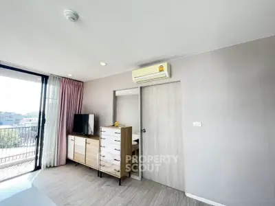 Modern living room with balcony view and stylish furniture in a bright apartment.