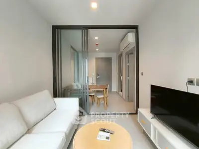 Modern living room with sleek furniture and sliding glass doors in a contemporary apartment.