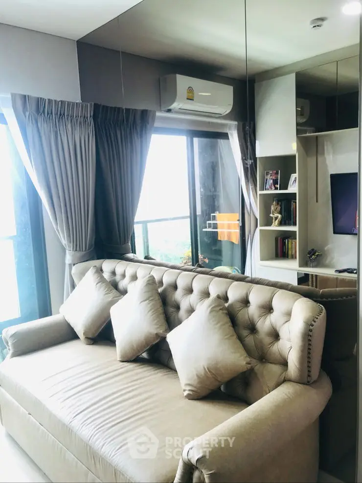 Modern living room with plush sofa and large windows offering natural light
