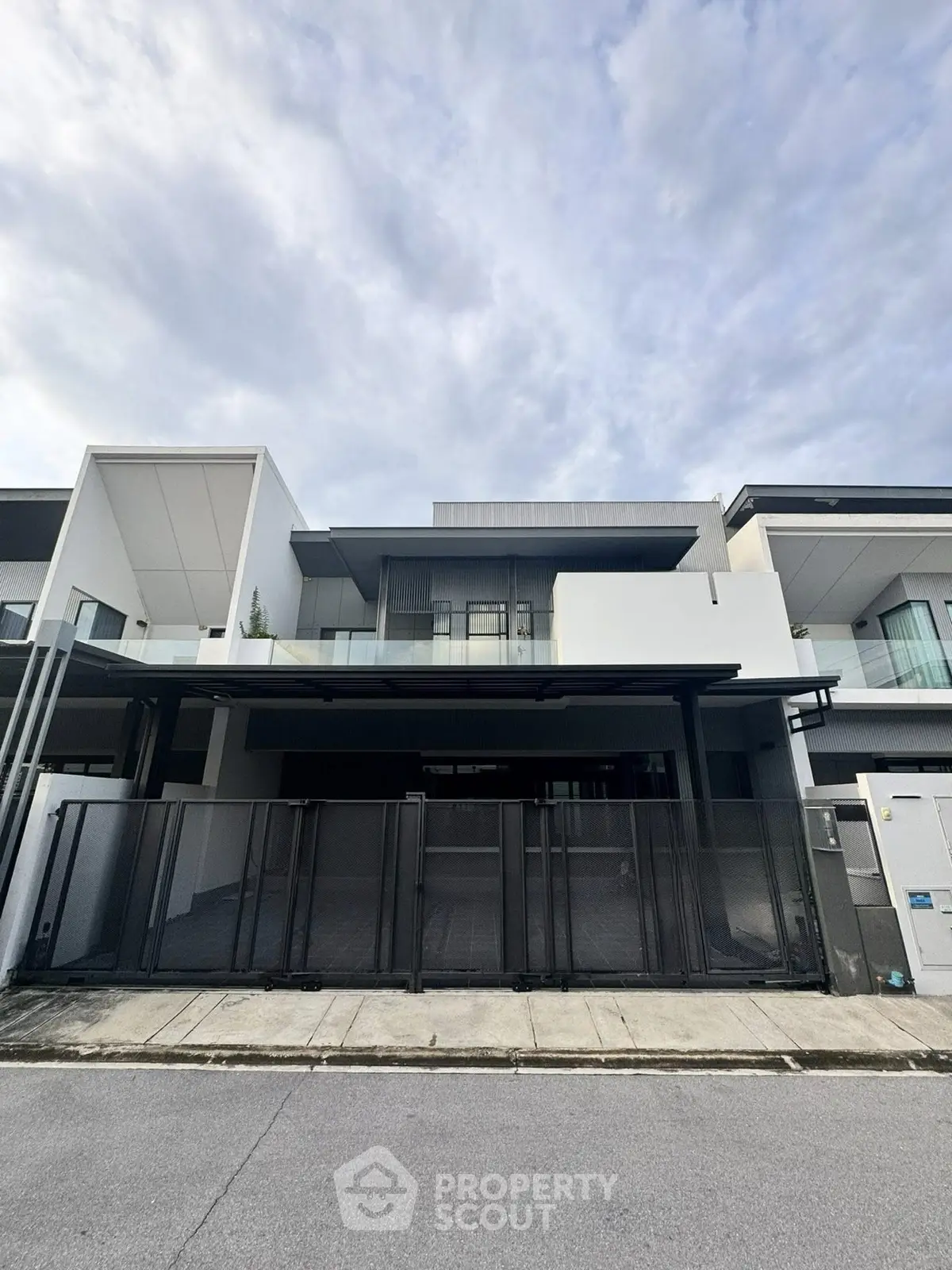 Modern architectural facade of a luxury residential building with sleek design and spacious balcony.
