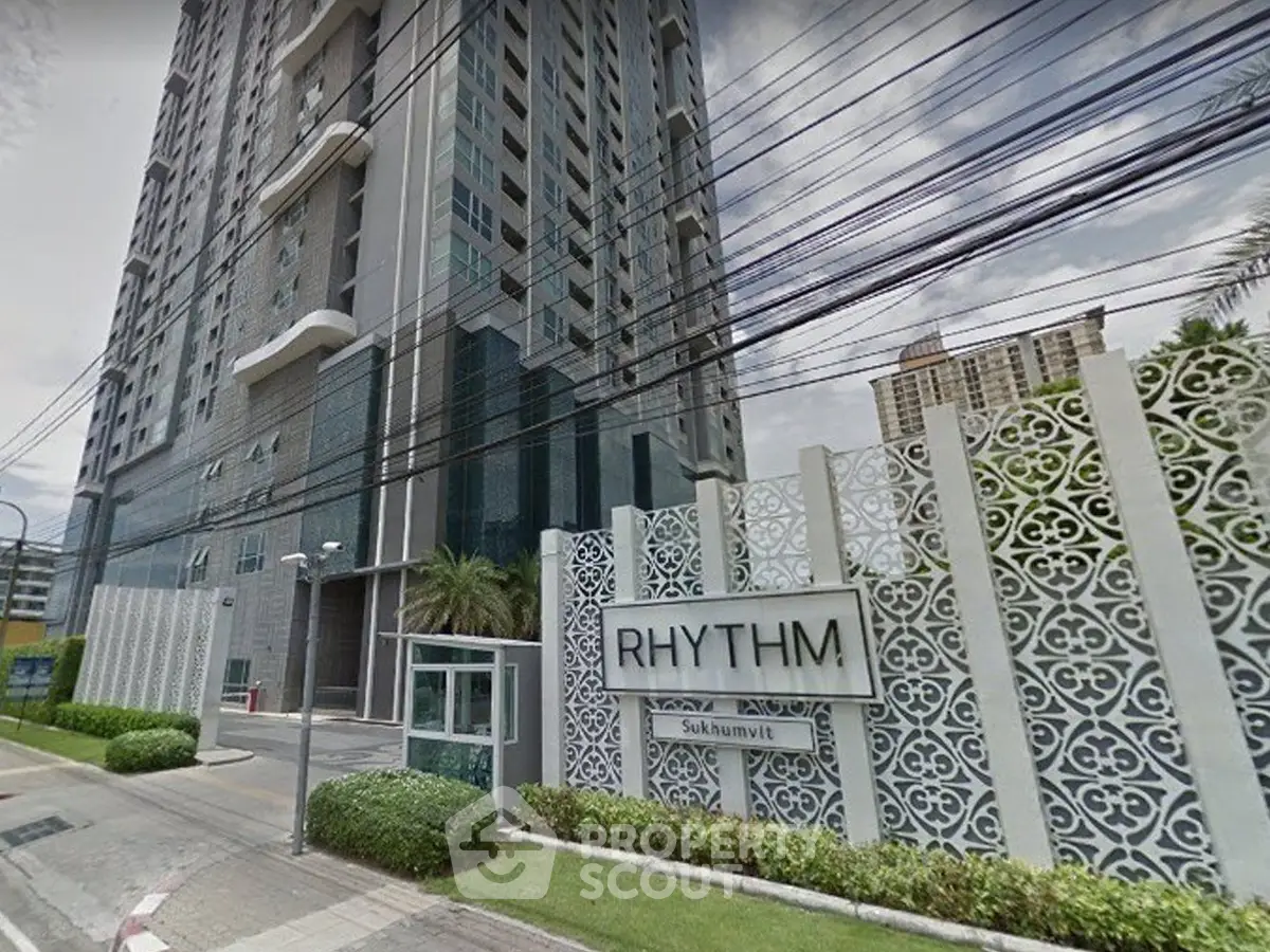 Modern high-rise building with stylish facade and prominent entrance signage.