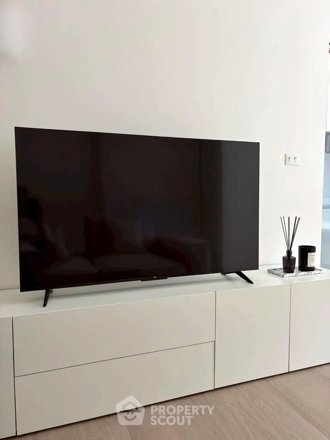 Modern living room with sleek TV on minimalist white cabinet