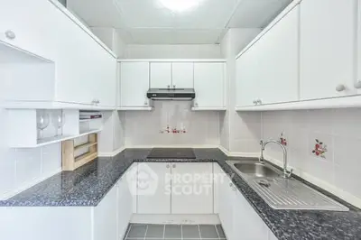 Modern kitchen with sleek white cabinets and dark countertops
