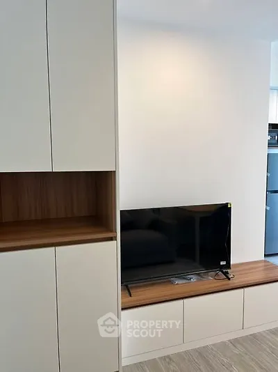 Modern living room with sleek cabinetry and flat-screen TV setup.
