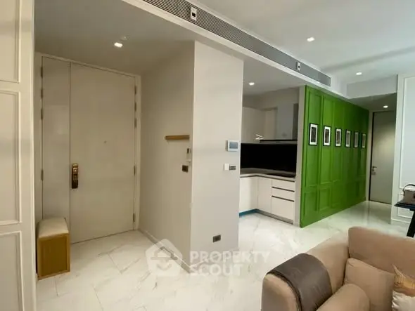 Modern apartment interior with stylish green accent wall and cozy seating area.