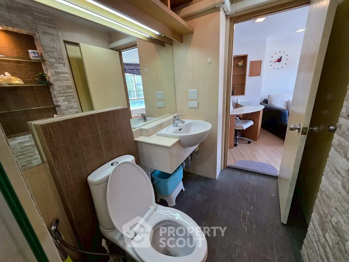 Modern bathroom with open view to a stylish study area, featuring sleek fixtures and contemporary design.