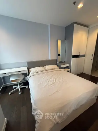 Modern bedroom with sleek furniture and ample storage in a stylish apartment.