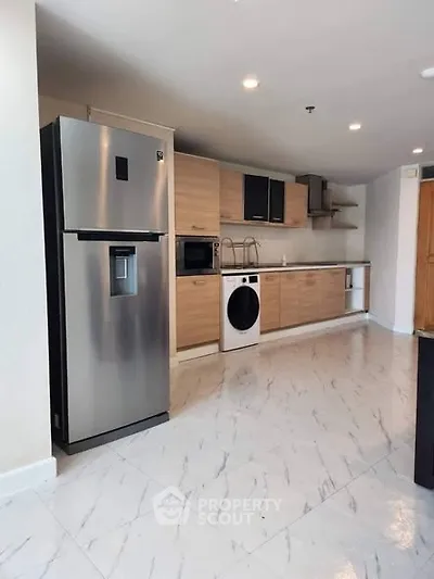 Modern kitchen with stainless steel fridge and washing machine