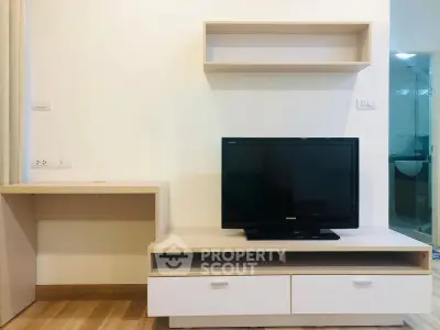 Modern living room with sleek TV stand and wall-mounted shelves in a stylish apartment.