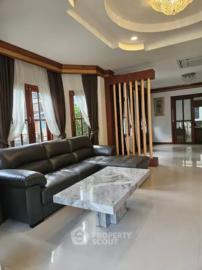 Spacious living room with elegant marble coffee table and luxurious leather sofa