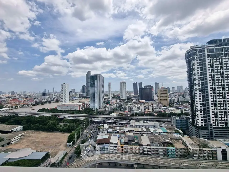 Stunning cityscape view from high-rise building with skyline and river in the background.