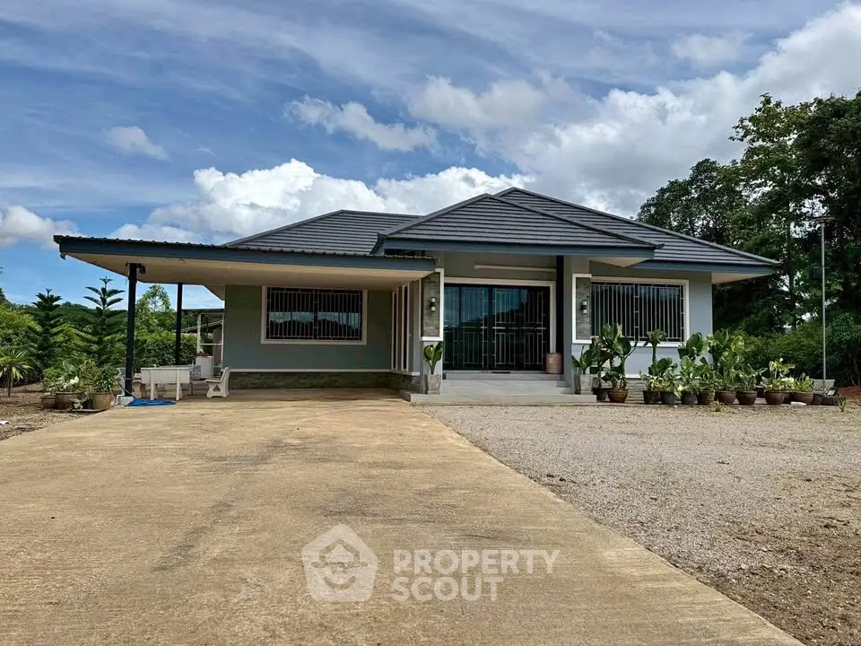 Charming single-story house with spacious driveway and lush greenery, perfect for serene living.