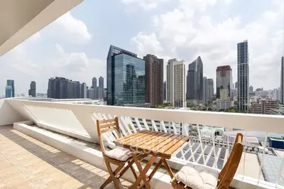 Spacious balcony with stunning city skyline view and cozy seating area.