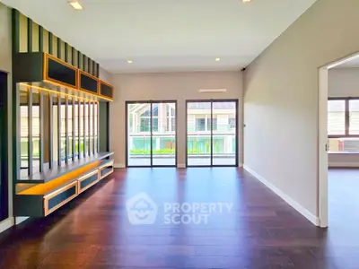 Spacious modern living room with large windows and elegant wood flooring