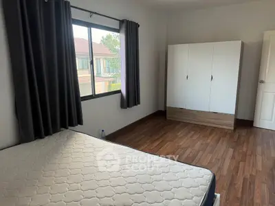 Spacious bedroom with large window and modern wardrobe
