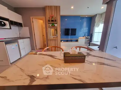 Modern open-plan living room with marble dining table and sleek kitchen design.
