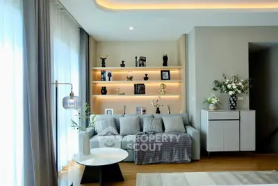 Elegant living room with modern decor and ambient lighting, featuring a cozy sofa and stylish shelving.
