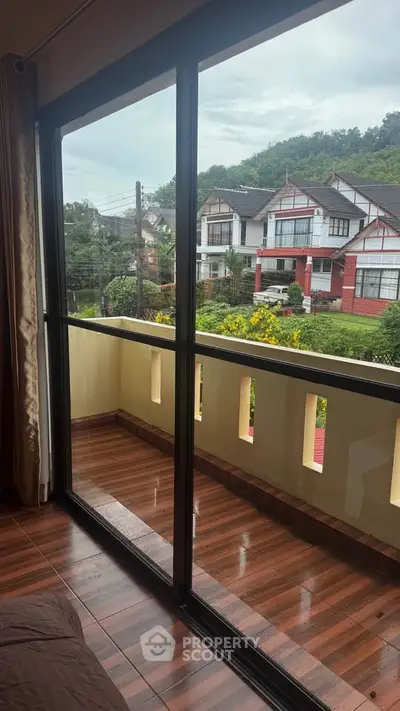 Charming balcony view with lush greenery and classic architecture, perfect for relaxation and enjoying the outdoors.