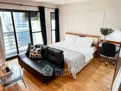 Spacious bedroom with city view, featuring a cozy bed, stylish sofa, and elegant wooden flooring.