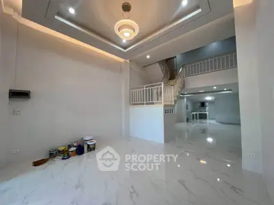 Spacious modern living room with high ceilings and elegant lighting, featuring glossy marble floors and open layout.