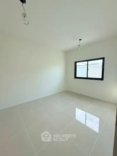 Spacious empty room with large window and glossy tiled floor, perfect for customization.