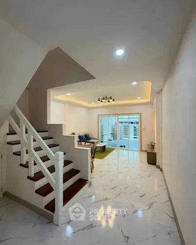 Spacious modern living room with elegant staircase and marble flooring