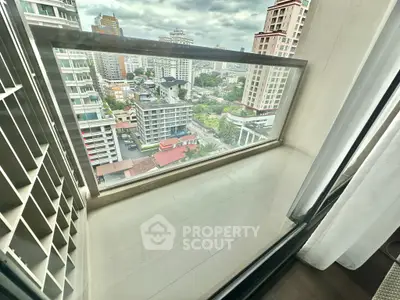 Stunning city view from a high-rise balcony with glass railing, perfect for urban living.