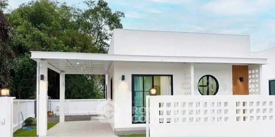 Modern minimalist white house with unique circular window and spacious carport