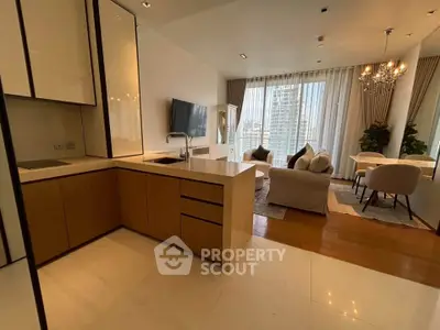 Modern open-layout living room with kitchen, featuring elegant decor and city view.