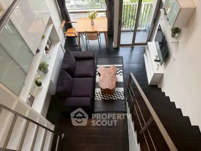 Modern loft-style living room with high ceiling and balcony view