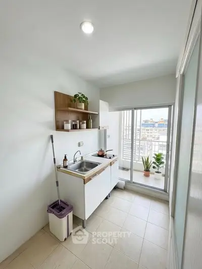 Bright kitchen with balcony access and modern sink setup, perfect for urban living.
