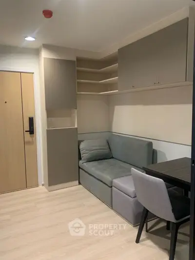 Modern apartment interior with cozy seating and sleek storage solutions.