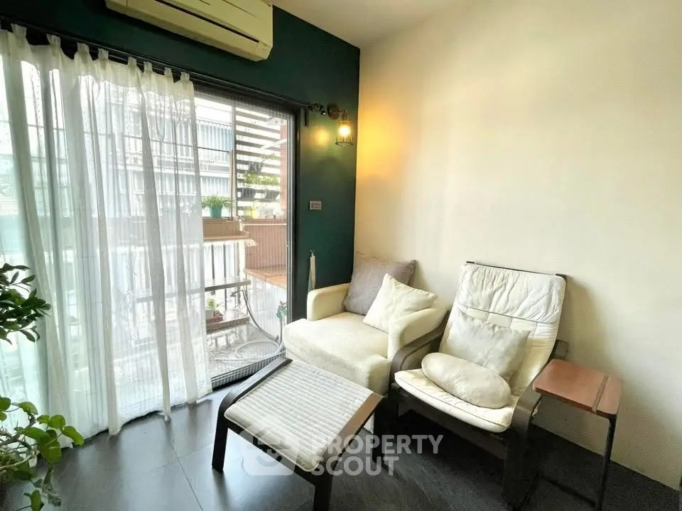 Cozy living room with balcony access and modern decor, perfect for relaxation.
